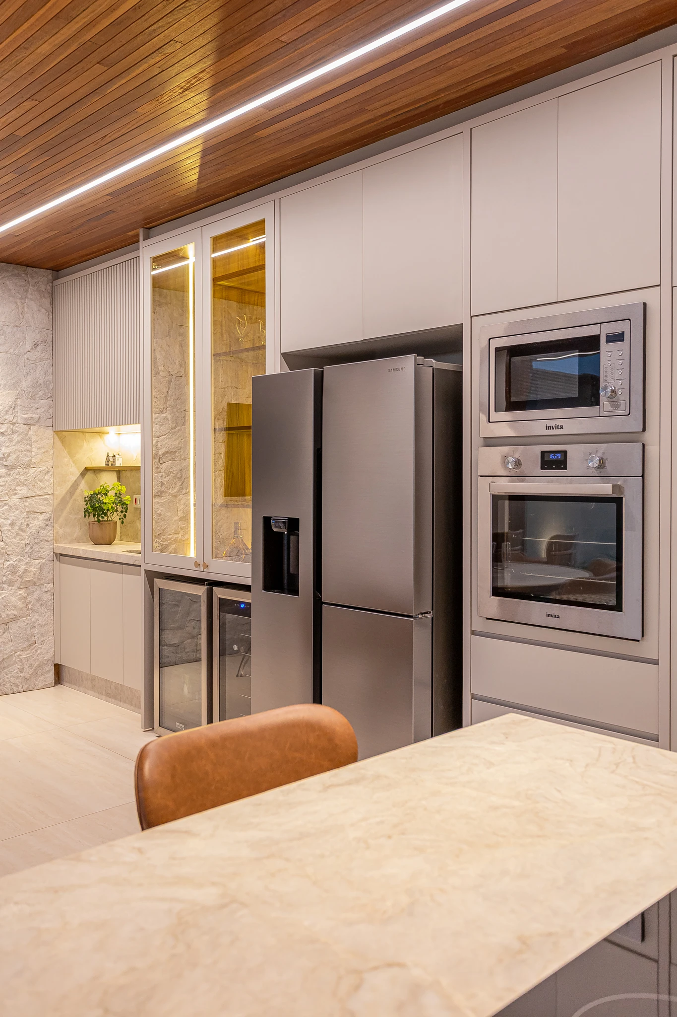 Vista ampla da área gourmet com mesa e ilha planejada